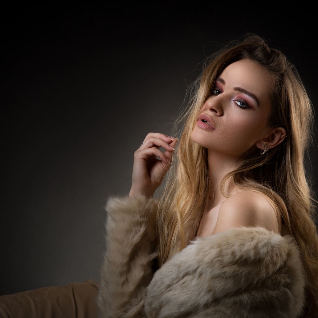Красивая девушка в шубе на сером фоне