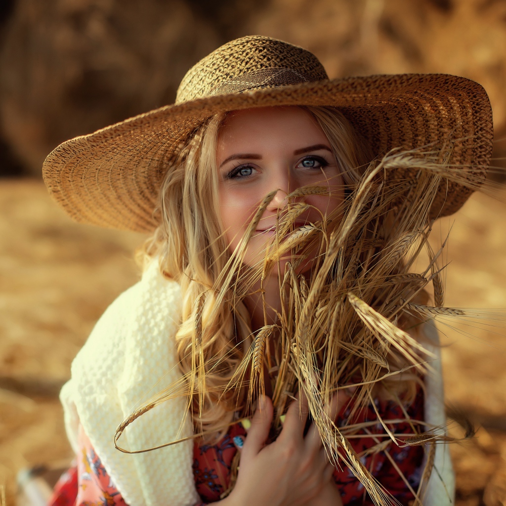 Красивая девушка в шляпе с колосьями в руке