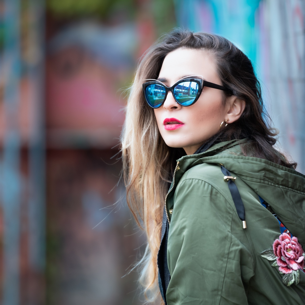 Красивая девушка в куртке и солнечных очках