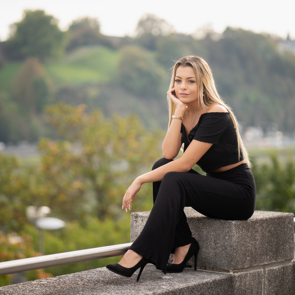 Красивая девушка в черном сидит