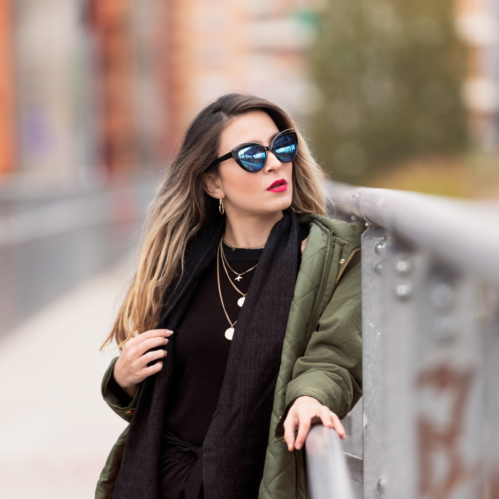 Красивая девушка в солнечных очках на мосту