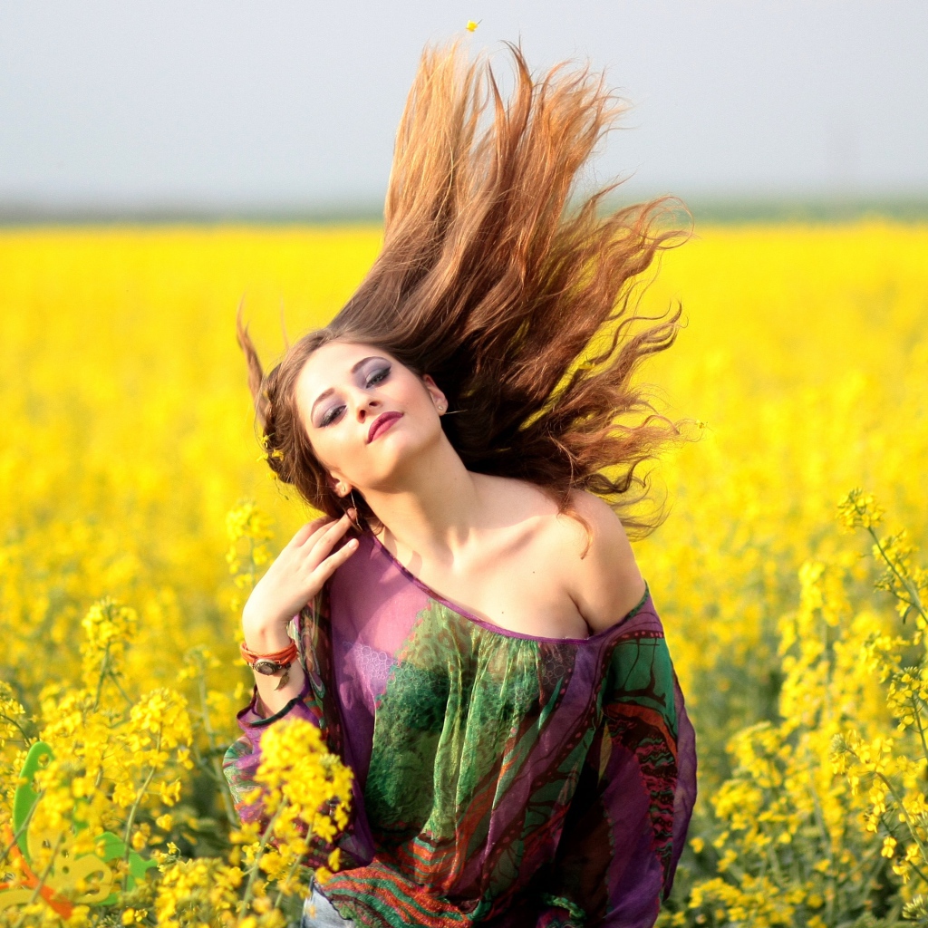 Красивая девушка на поле с желтыми цветами