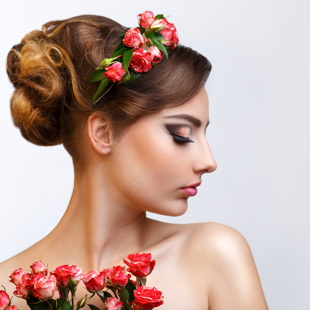 Красивая девушка с прической и венком из роз в волосах 