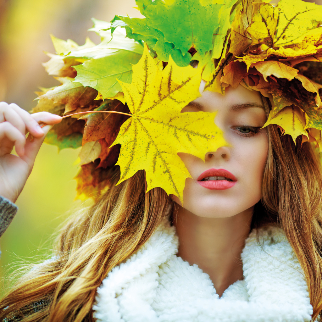 Красивая девушка с венком из листьев осенью
