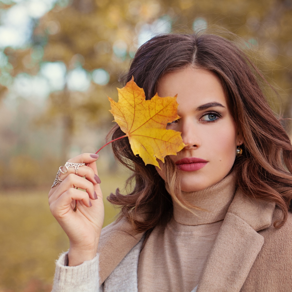 Красивая девушка с осенним листом в руке