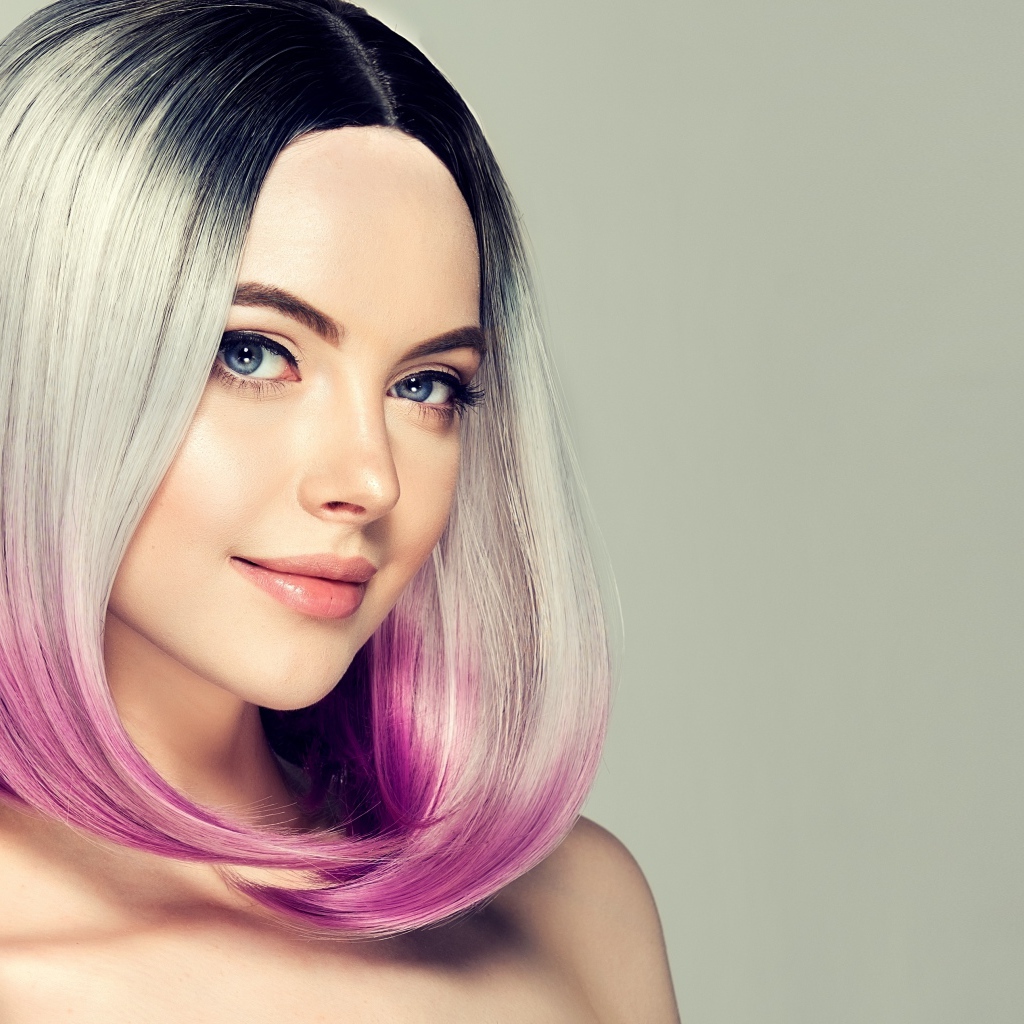 Красивая девушка с крашеными волосами на сером фоне