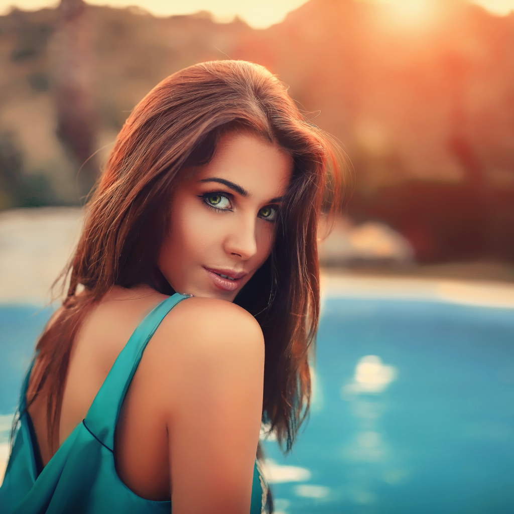 Красивая зеленоглазая шатенка у бассейна