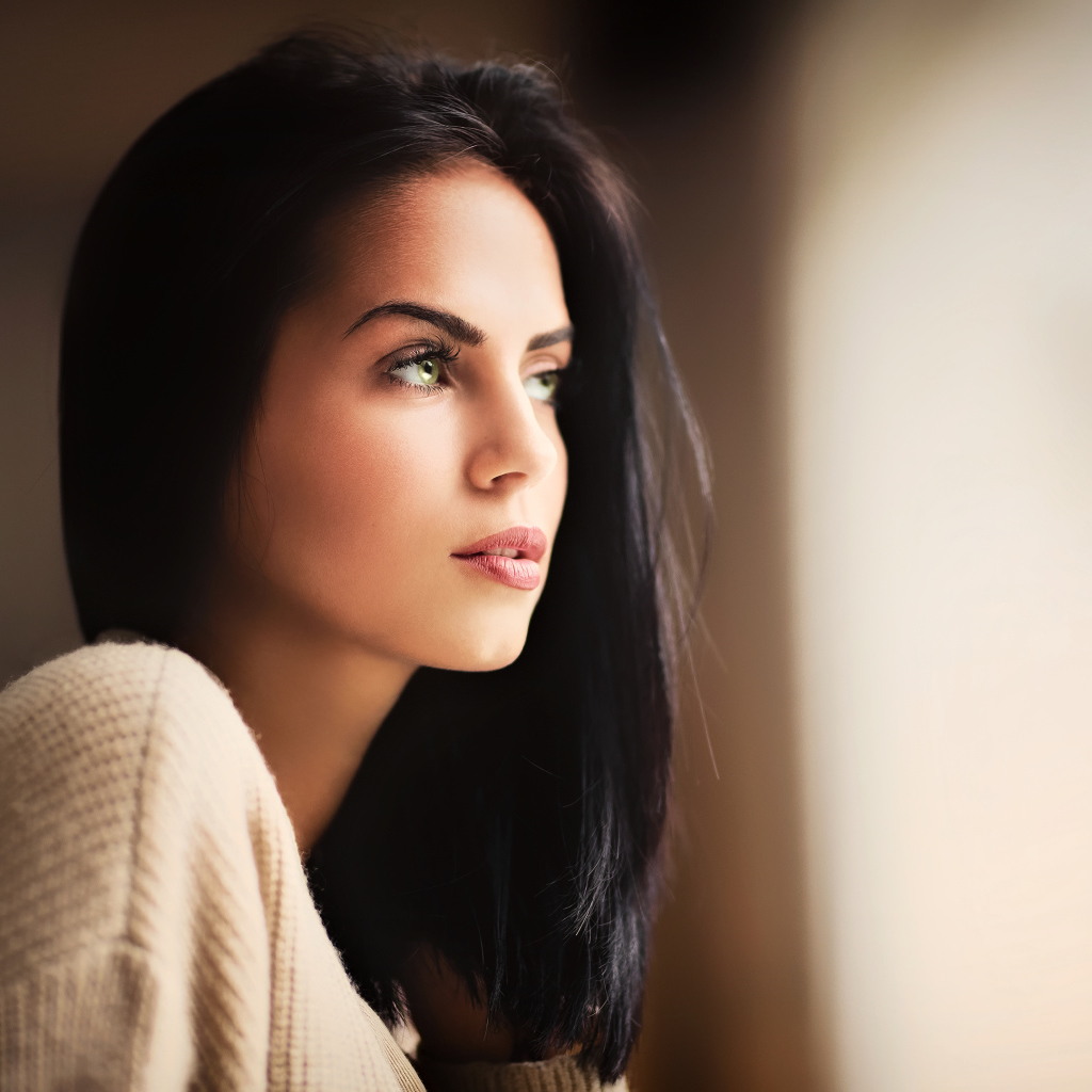 Красивая девушка зеленоглазая смотрит в окно 