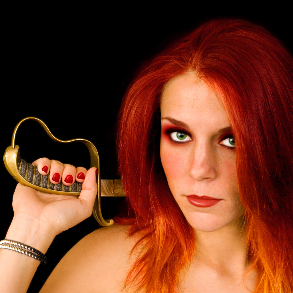 Красивая зеленоглазая девушка с зелеными глазами с саблей в руке