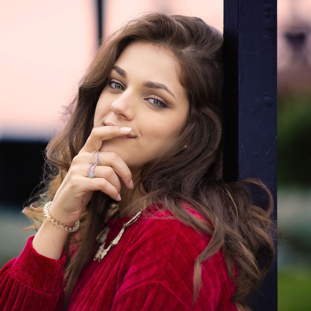 Красивая длинноволосая шатенка с рукой у лица