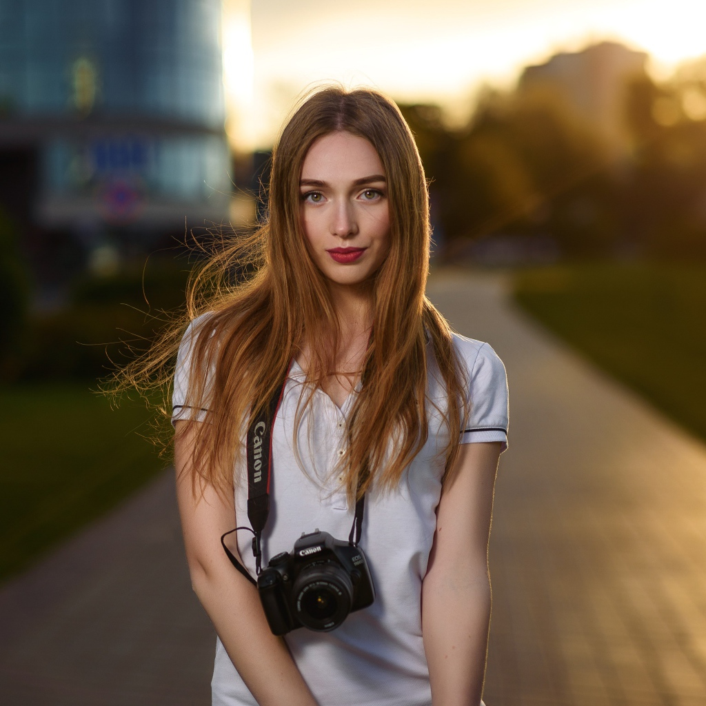 Красивая длинноволосая девушка с фотоаппаратом