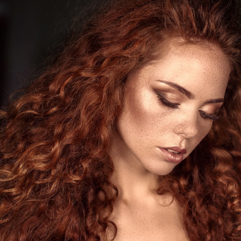 Красивая скромная рыжеволосая девушка с веснушками