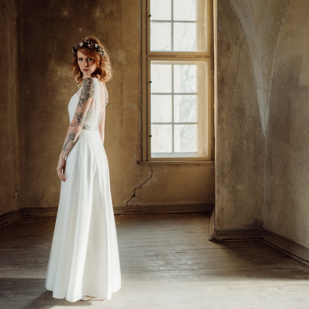 Красивая рыжеволосая девушка в белом платье с  татуировками на теле 