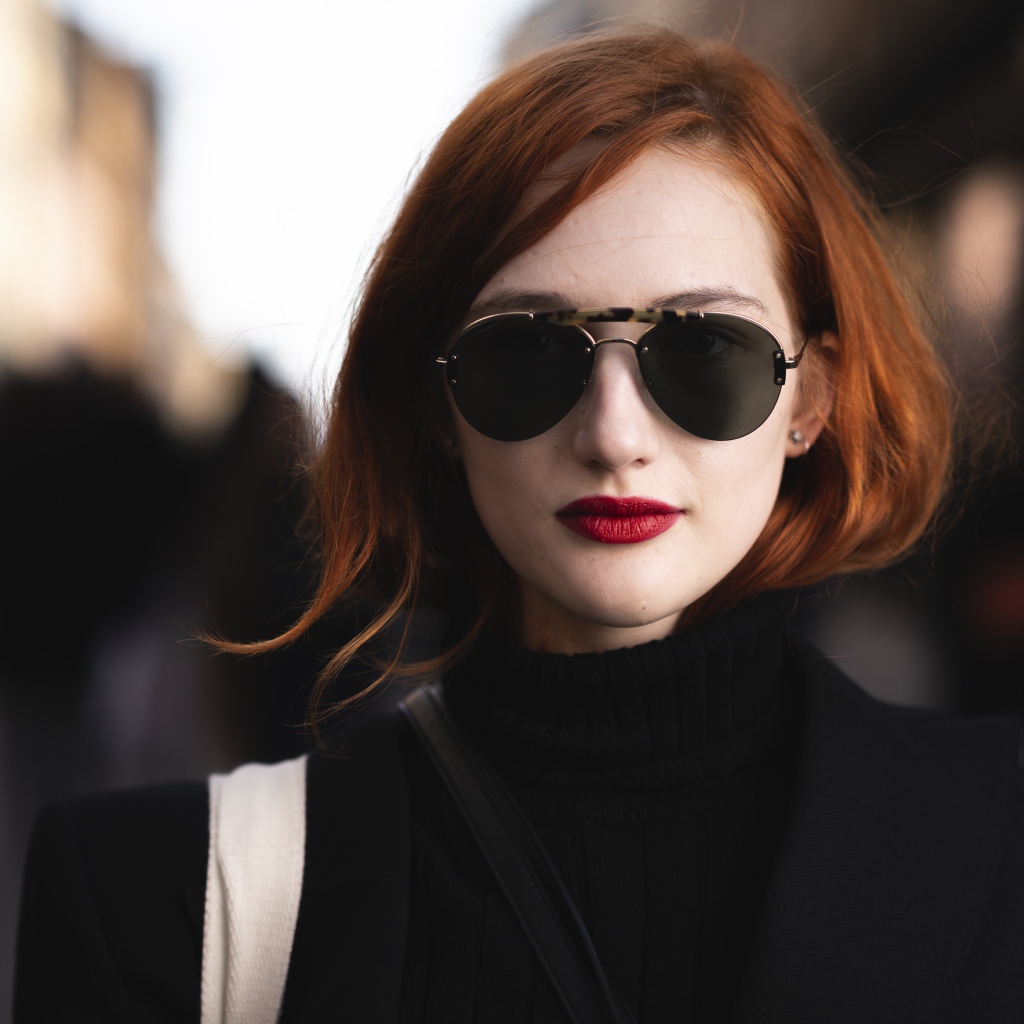 Красивая рыжеволосая девушка в темных очках