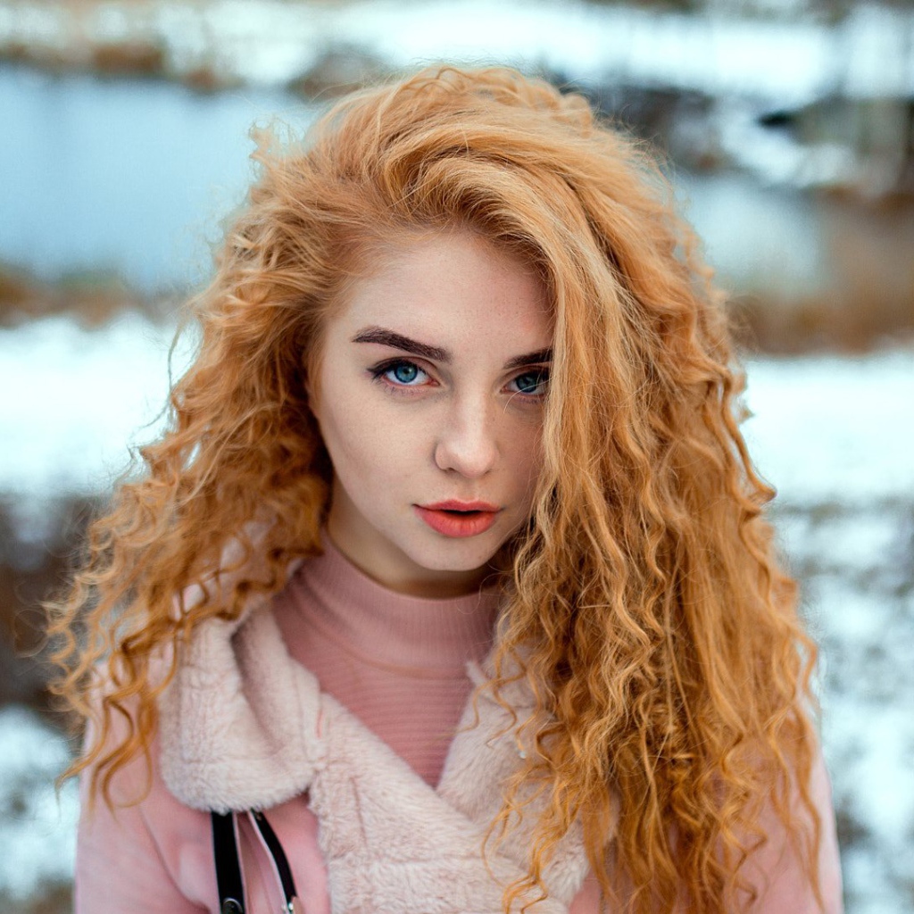 Красивая рыжеволосая девушка с голубыми глазами зимой