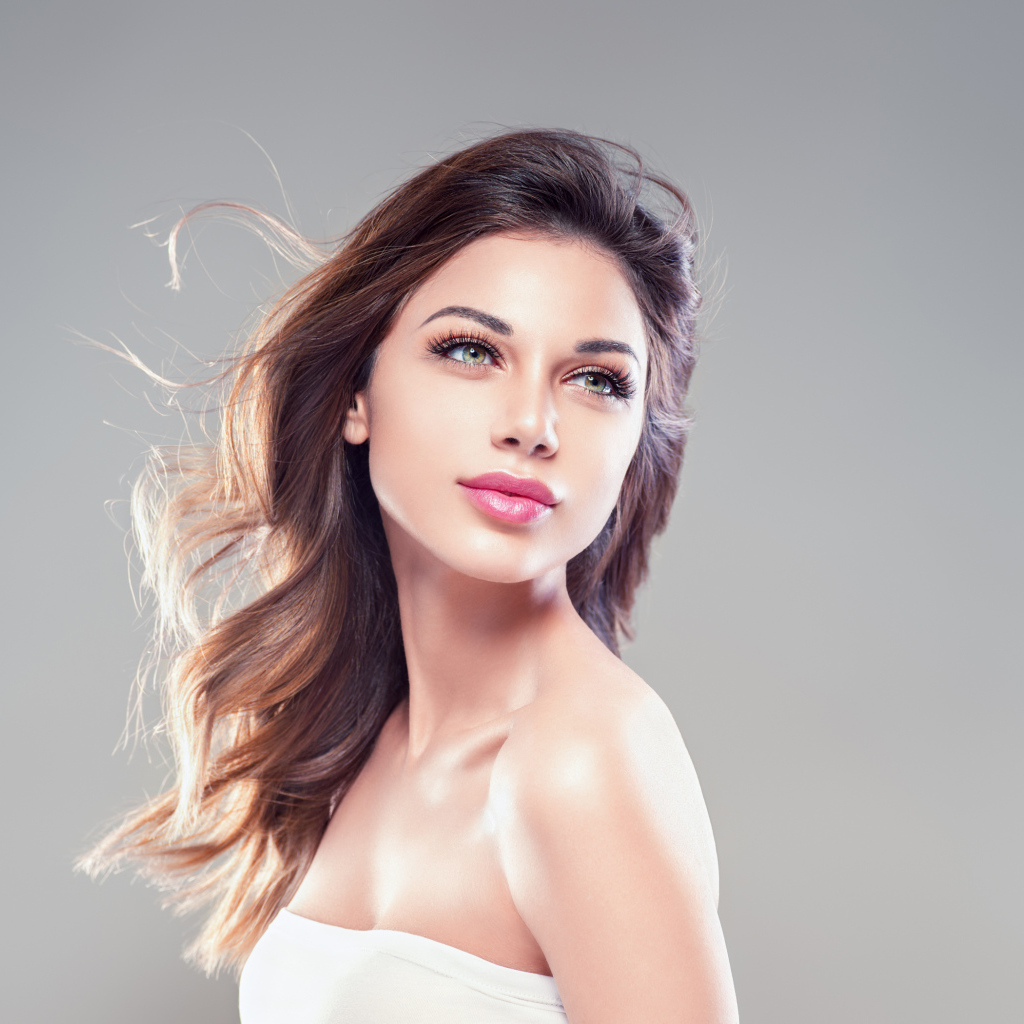 Красивая нежная девушка шатенка на сером фоне