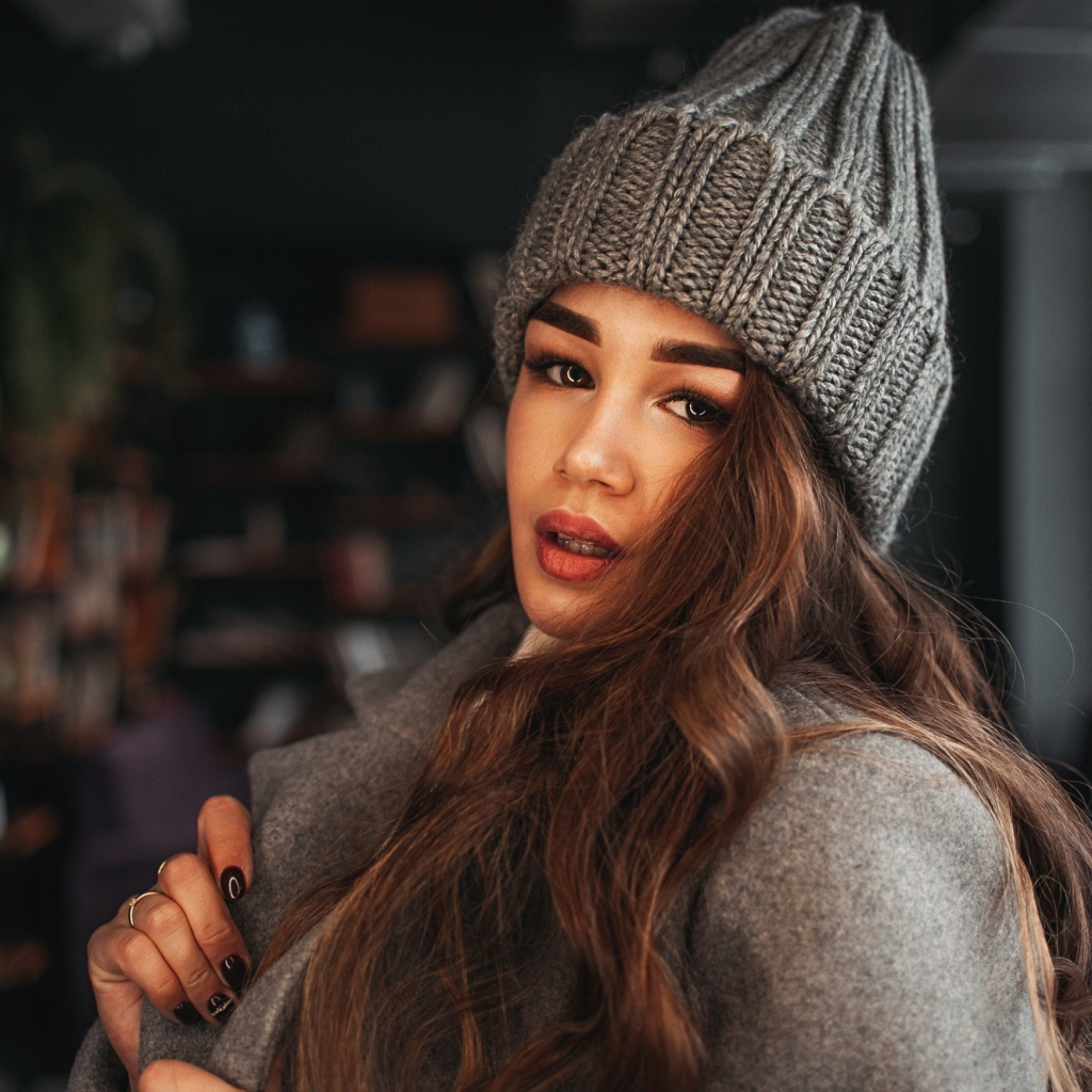 Красивая молодая девушка в пальто в вязаной шапке