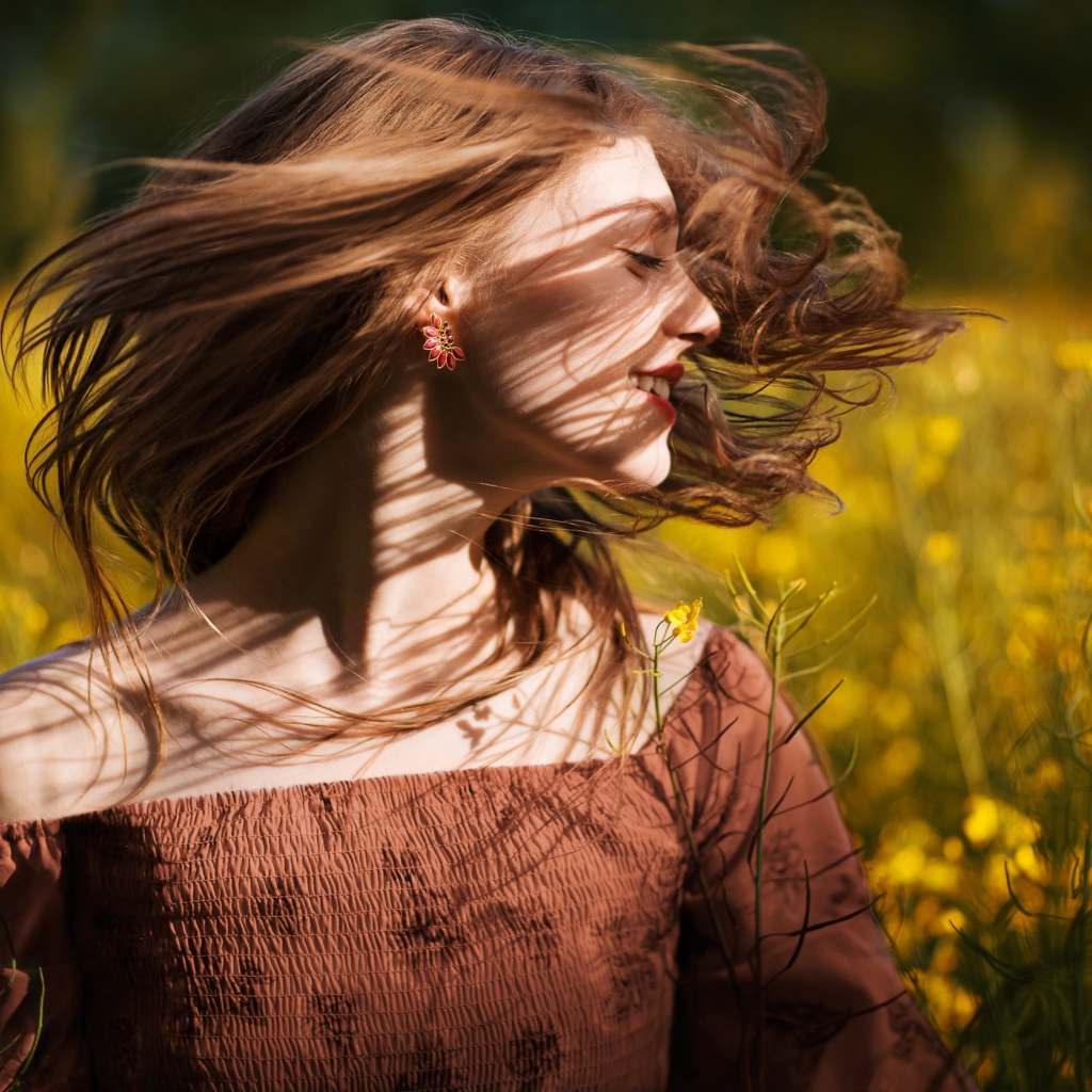 Красивая молодая девушка на поле с желтыми цветами