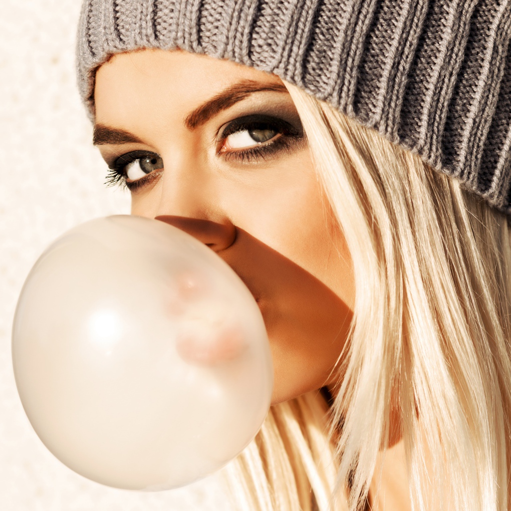 Девушка блондинка с жвачкой во рту крупным планом