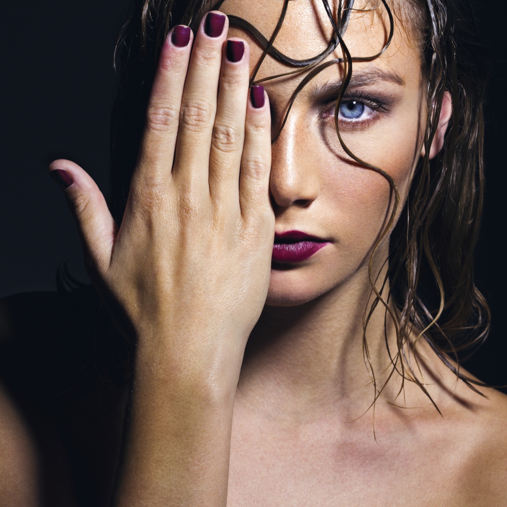 Голубоглазая девушка закрывает лицо рукой