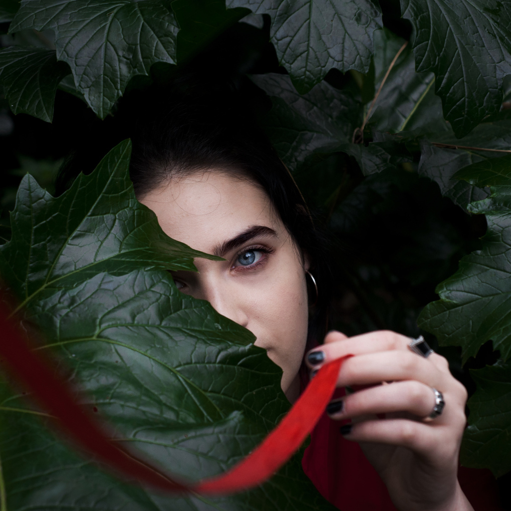 Голубоглазая девушка в больших зеленых листьях