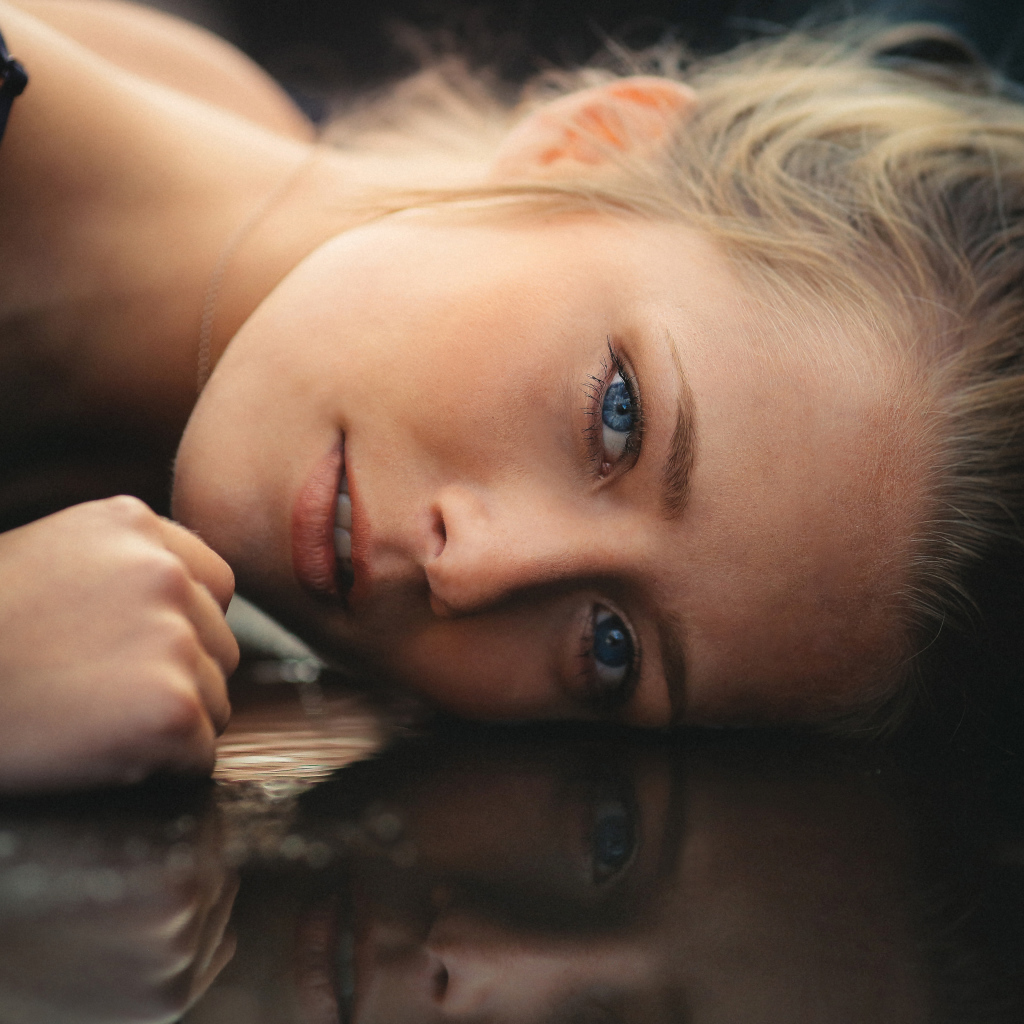 Голубоглазая девушка модель лежит на полу