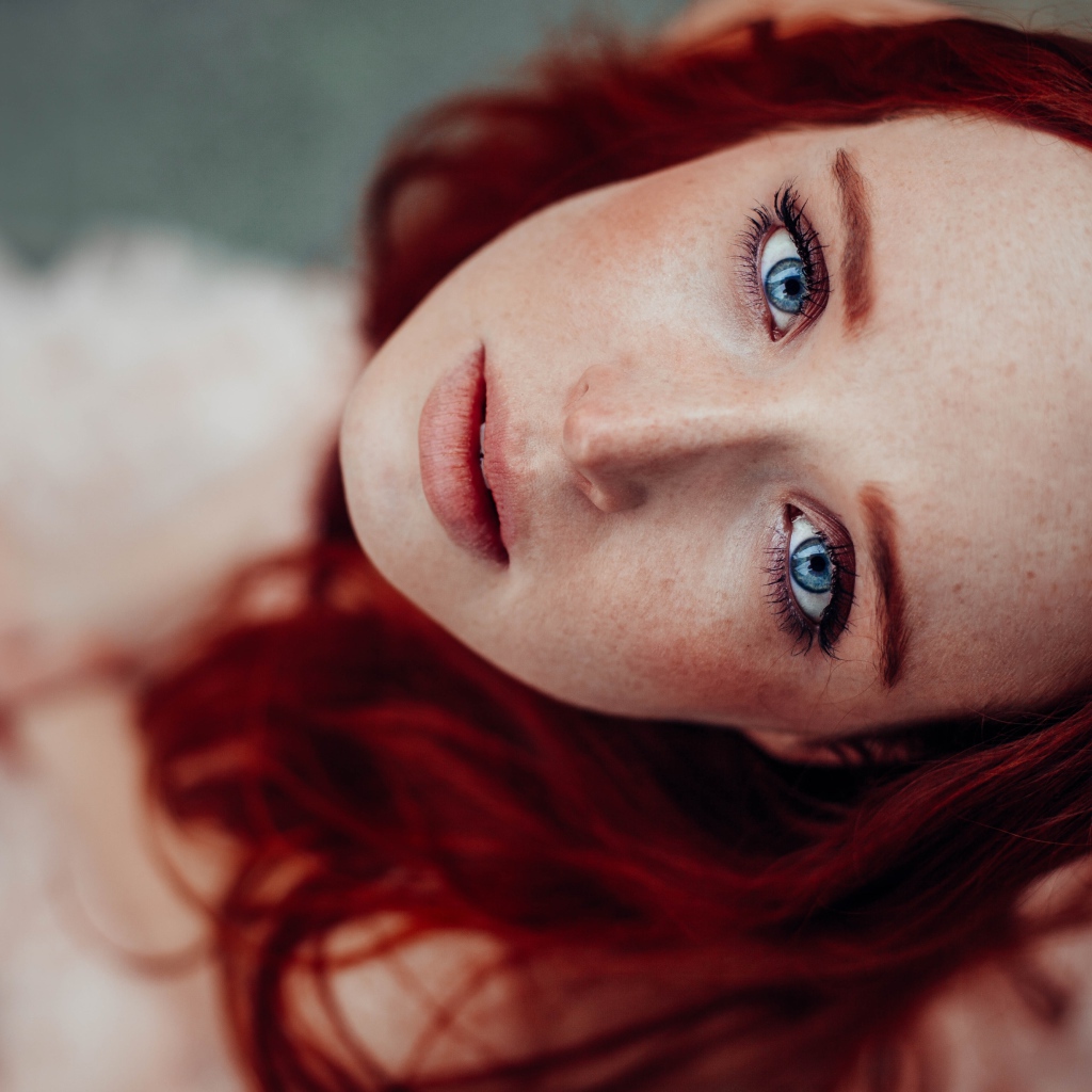 Голубоглазая рыжеволосая девушка с веснушками на лице