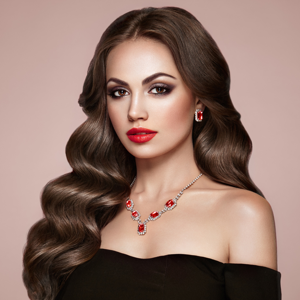 Яркая красивая девушка с украшениями на розовом фоне