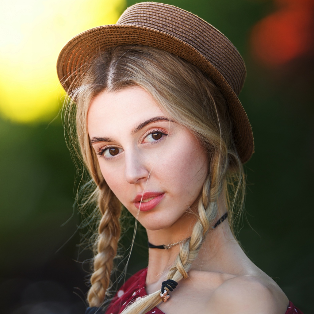 Кареглазая девушка с косами на голове в шляпе