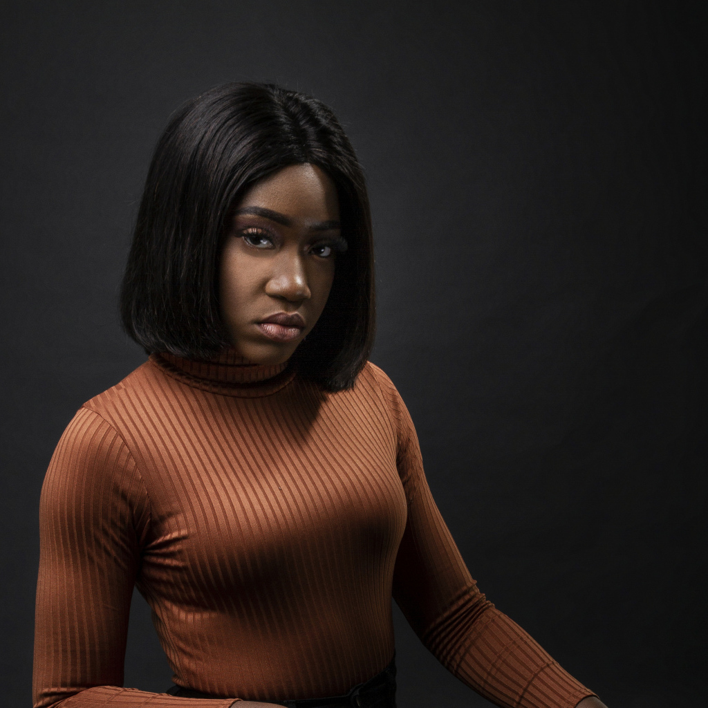 Темнокожая девушка с короткой стрижкой на сером фоне