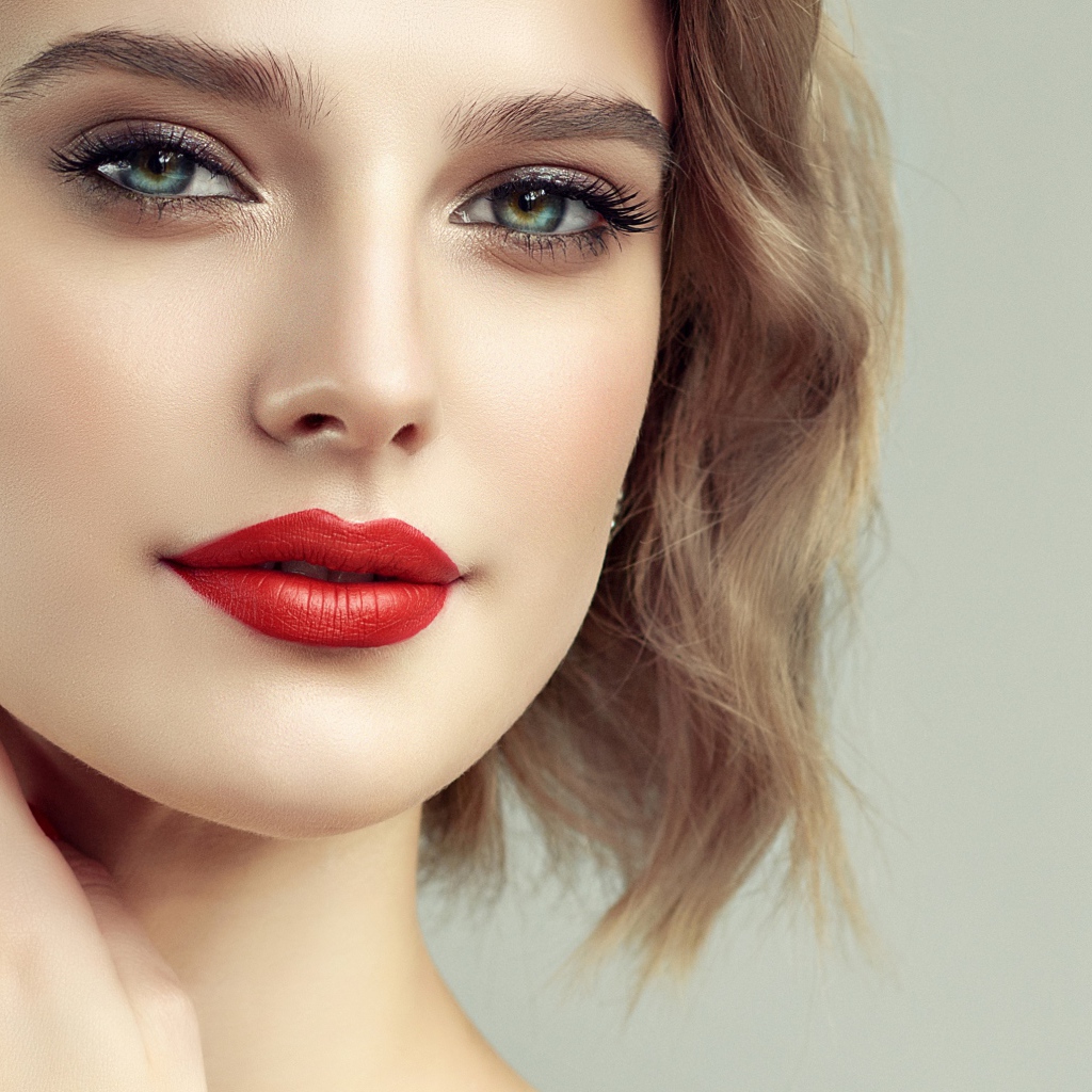 Лицо девушка с красивым макияжем на сером фоне