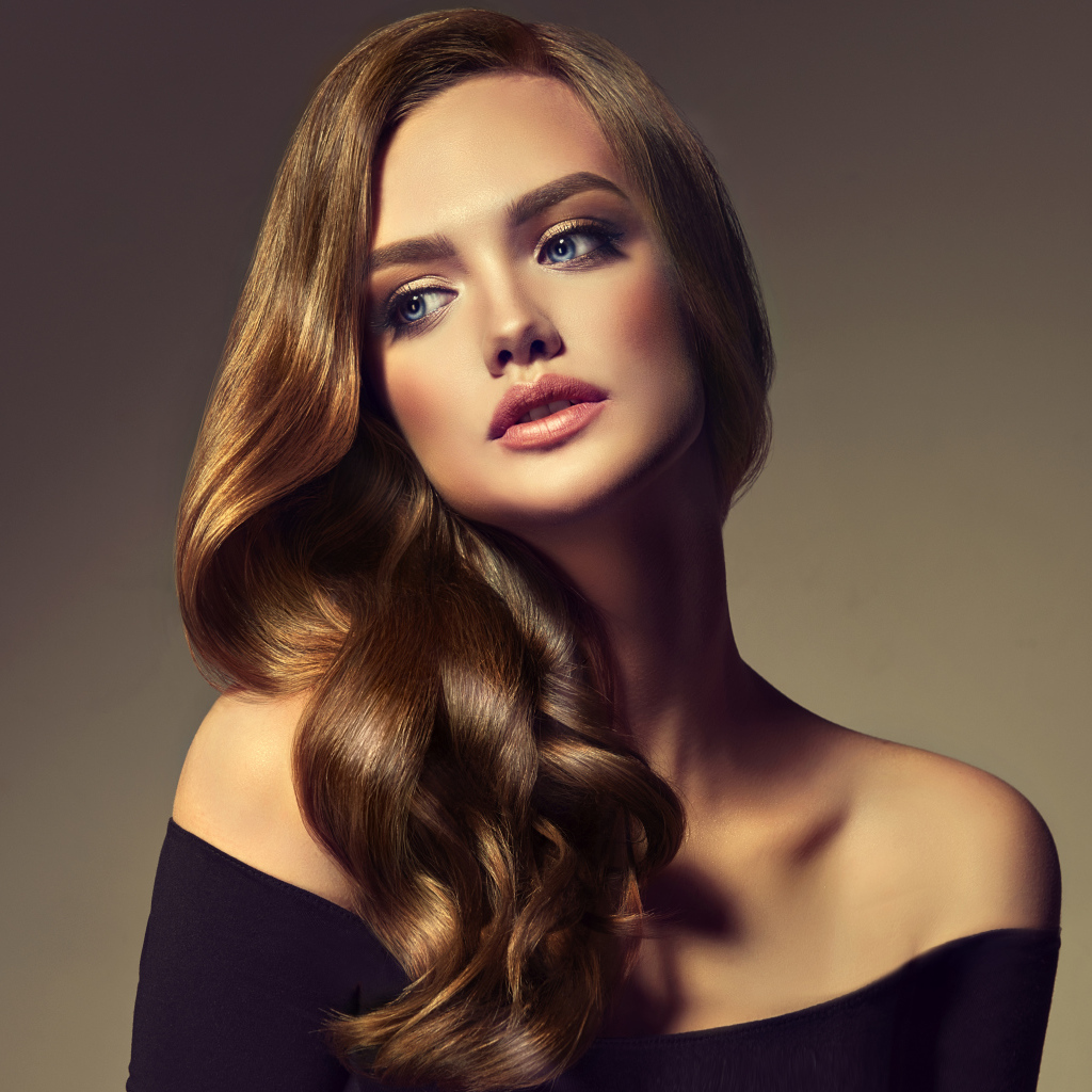 Нежная голубоглазая модель с длинными волосами на сером фоне