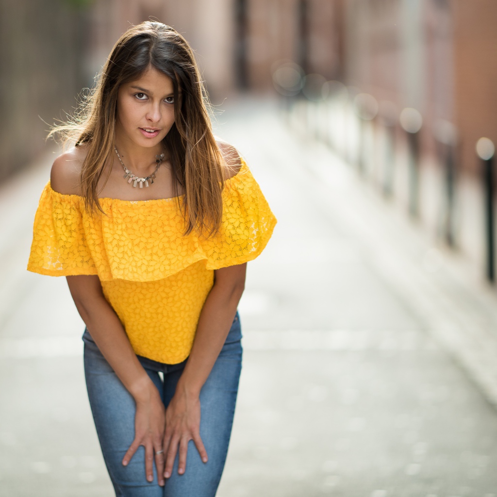 Девушка в джинсах стоит на улице 