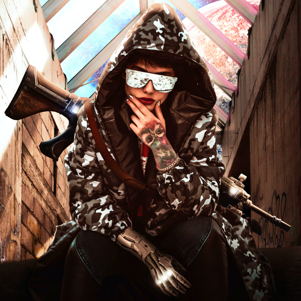 Девушка с оружием в худи и очках 