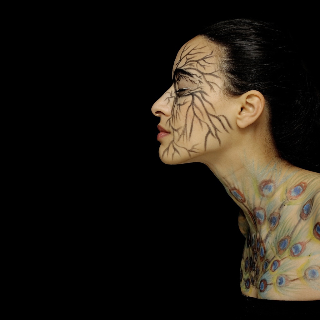 Девушка с рисунками на теле на черном фоне