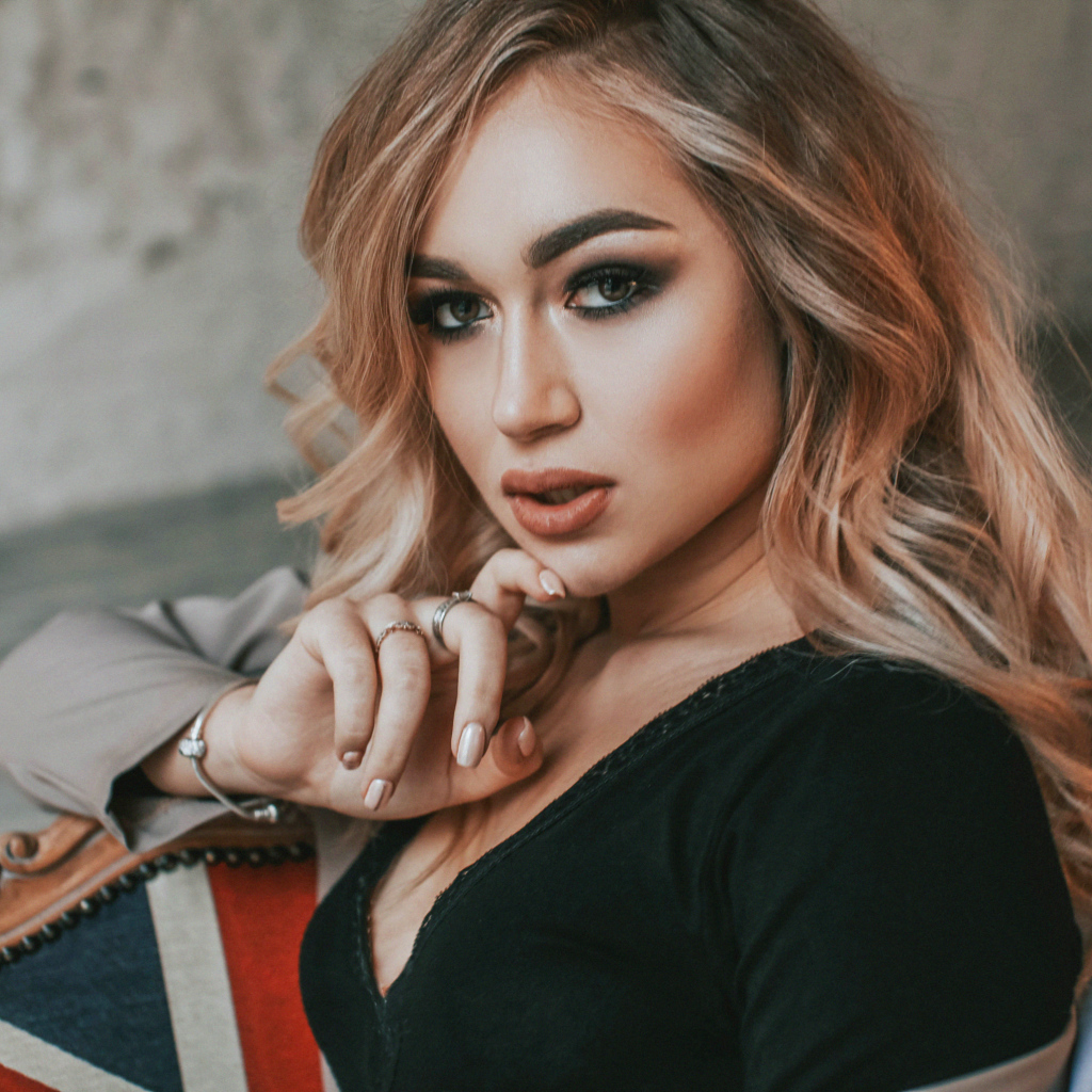 Горячая девушка с макияжем сидит на стуле