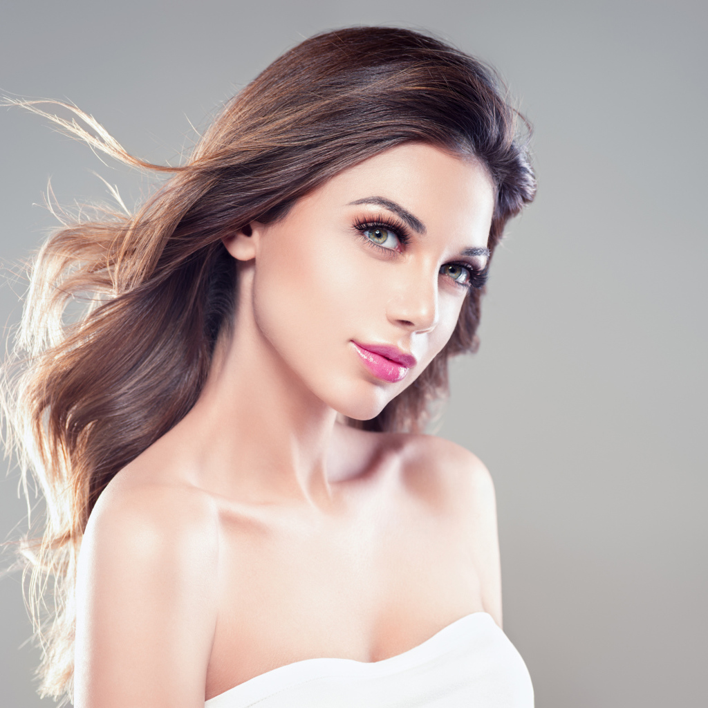 Настоящая девушка с длинными волосами на сером фоне