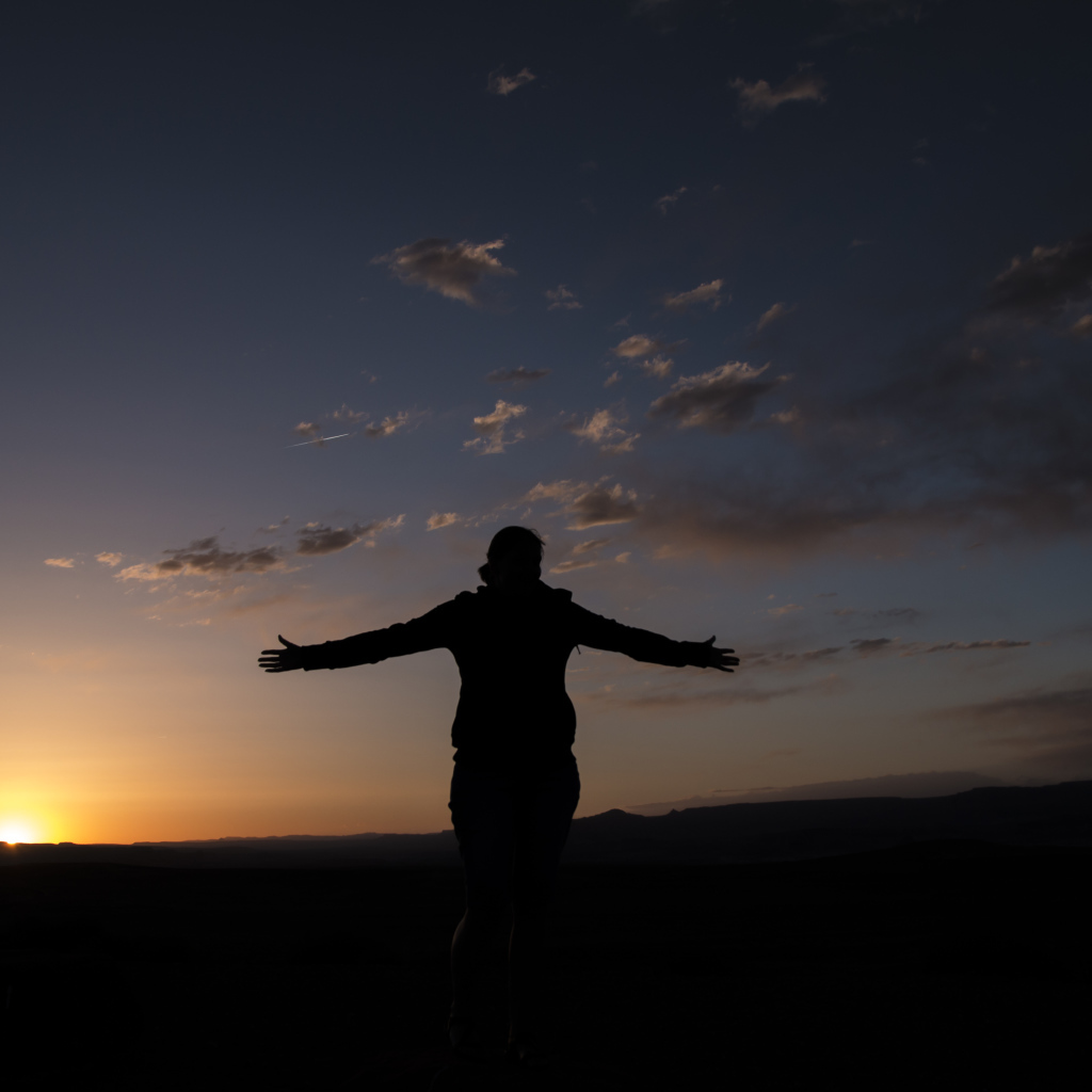 Силуэт девушки на фоне неба на закате