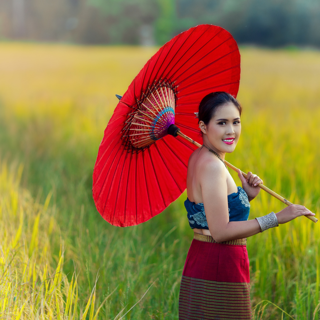 Улыбающаяся девушка азиатка с красным зонтом