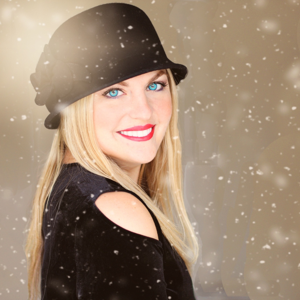 Улыбающаяся голубоглазая девушка в черной шляпе