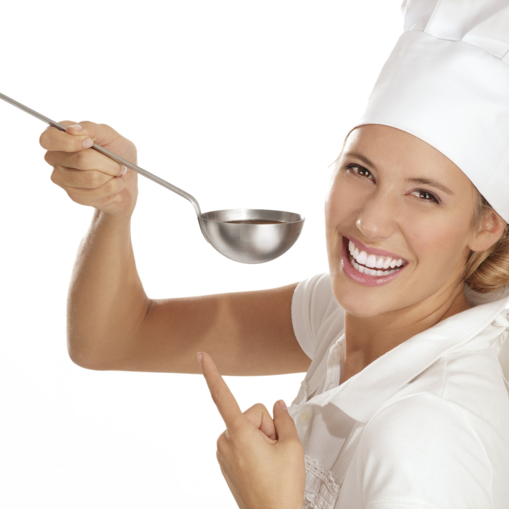 Улыбающаяся девушка в костюме повара с половником