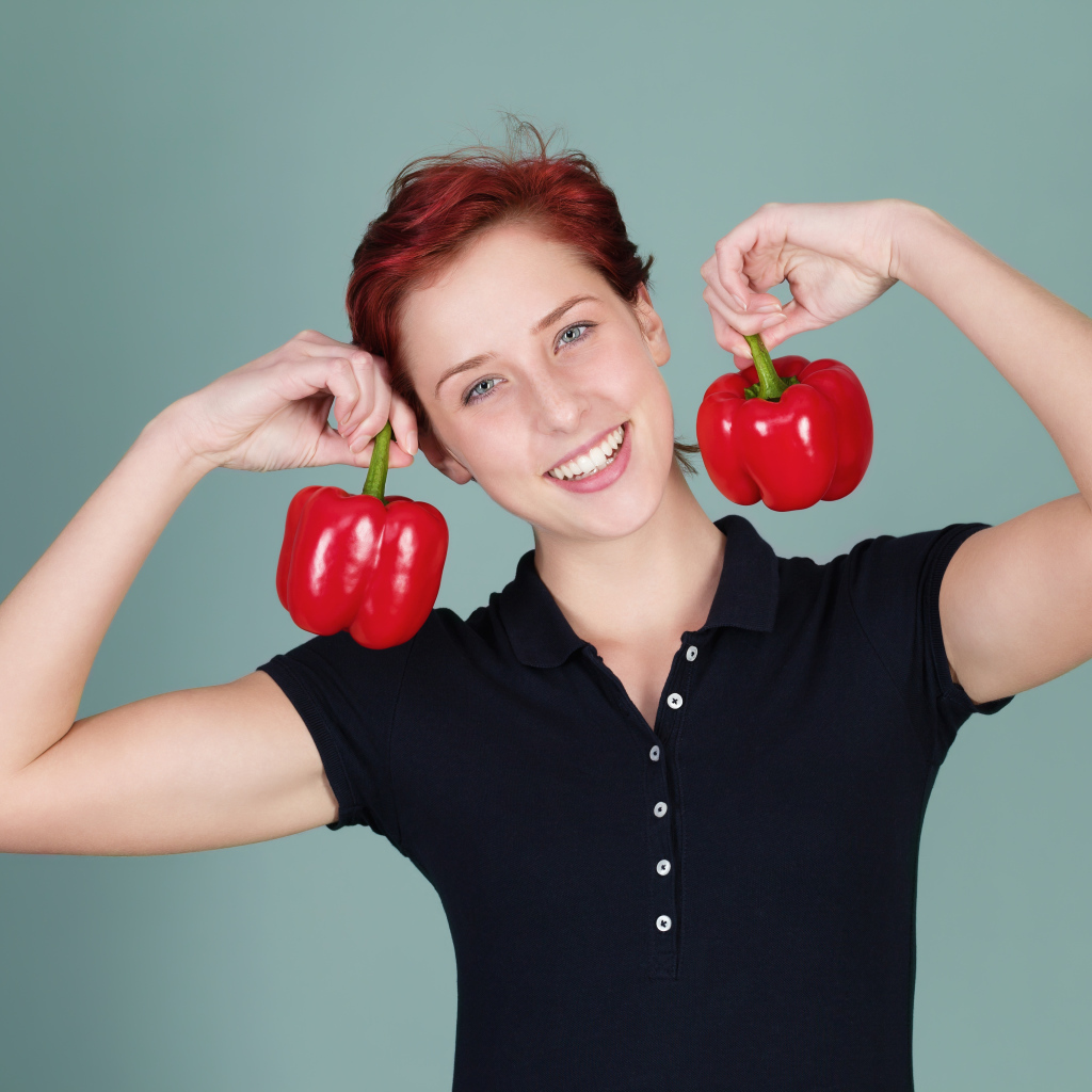 Улыбающаяся девушка с болгарским перцем в руках