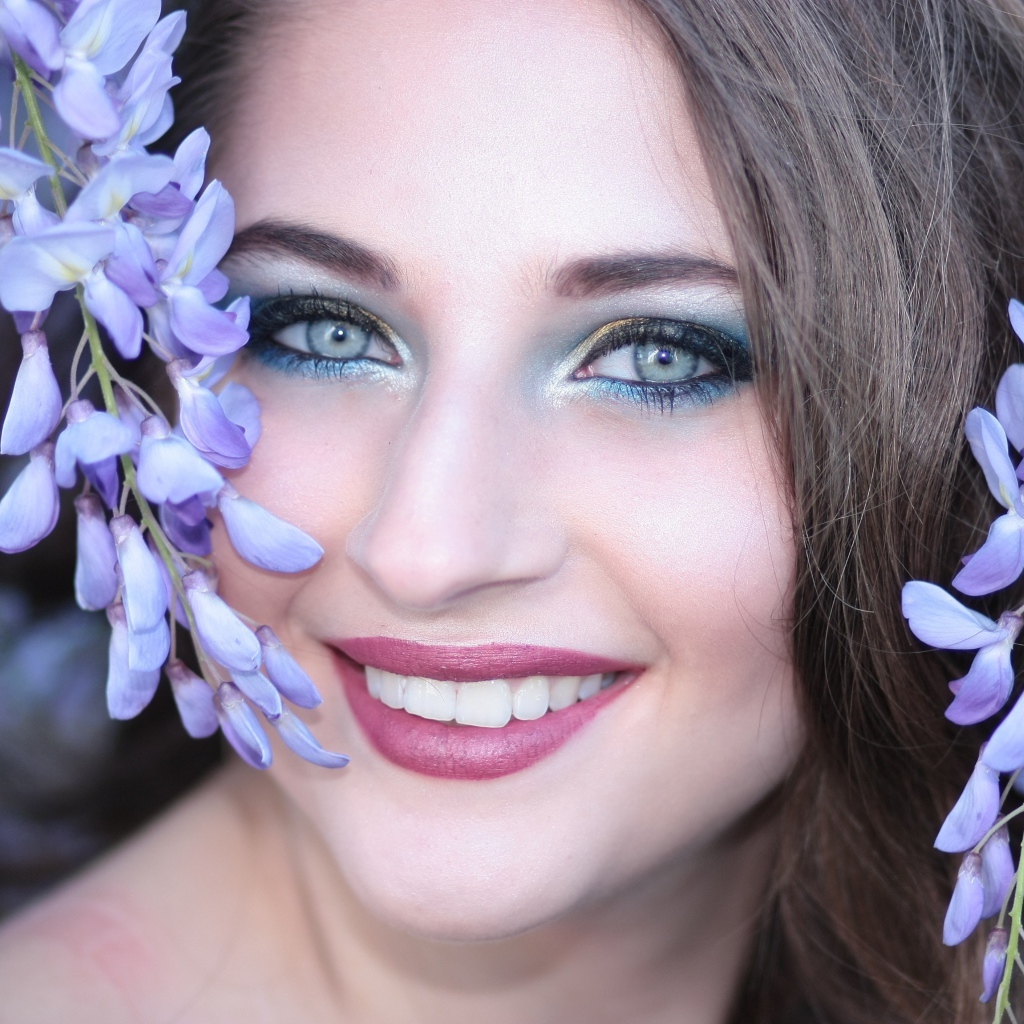 Улыбающаяся девушка с цветами глицинии