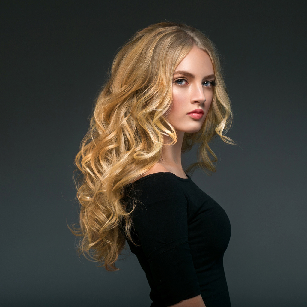 Стильная голубоглазая длинноволосая девушка в черном наряде