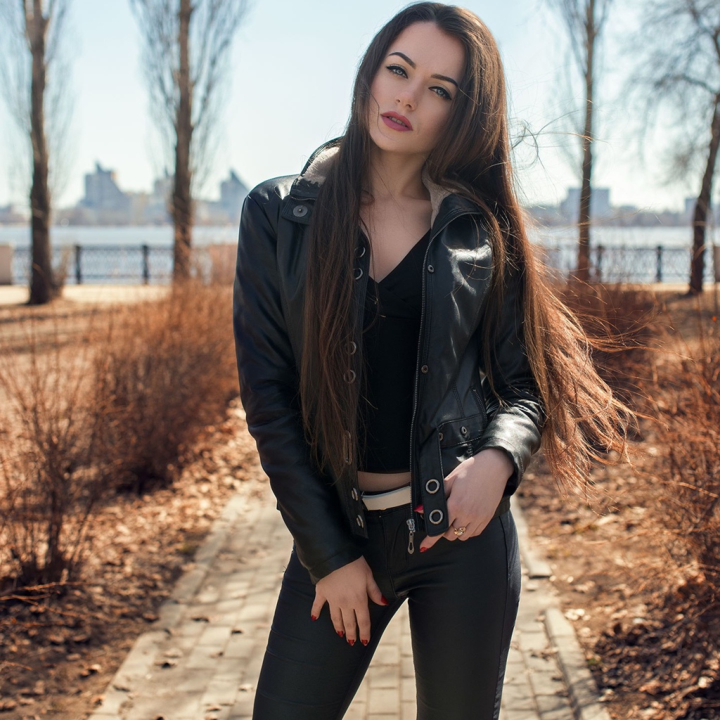 Стильная девушка в черной куртке в парке 