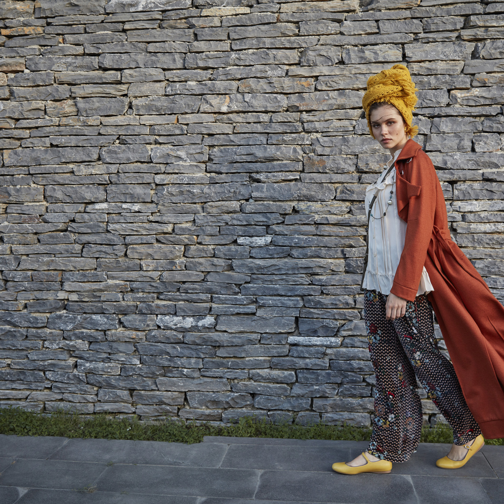 Стильная девушка на фоне стены 