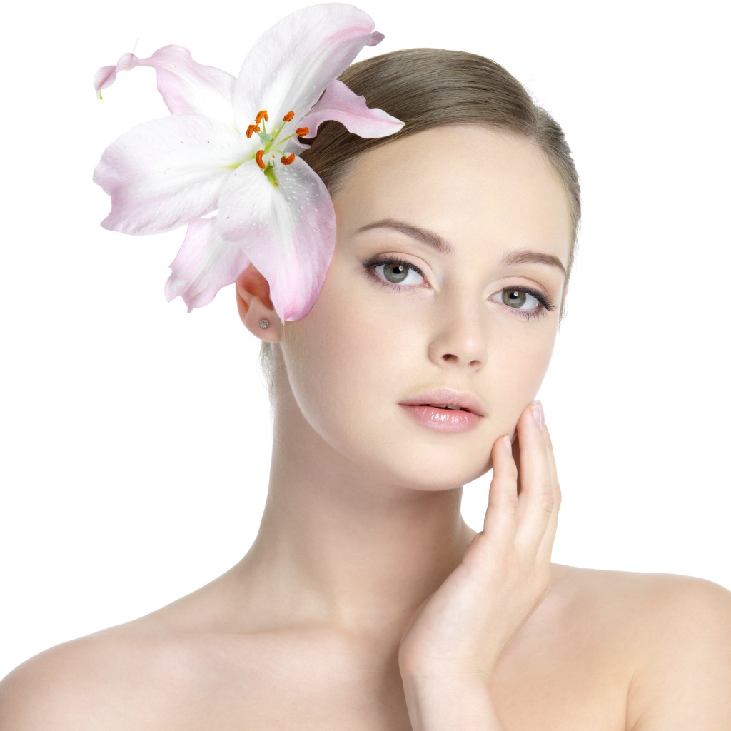 Нежная красивая девушка с лилией в волосах на белом фоне 