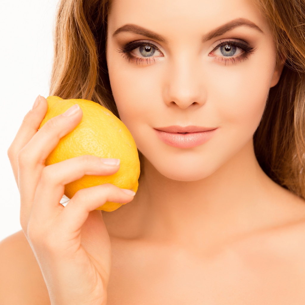 Нежная голубоглазая девушка с лимоном в руке
