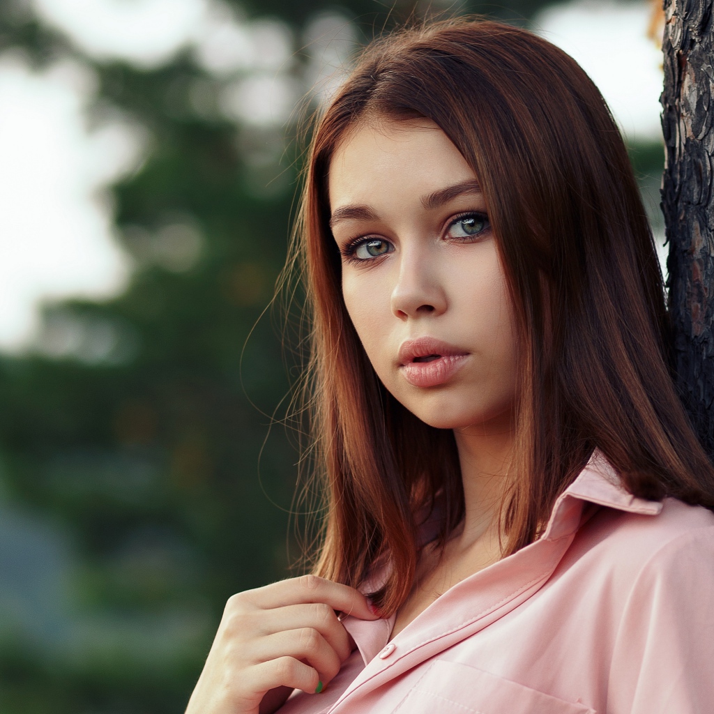 Нежная девушка стоит у дерева