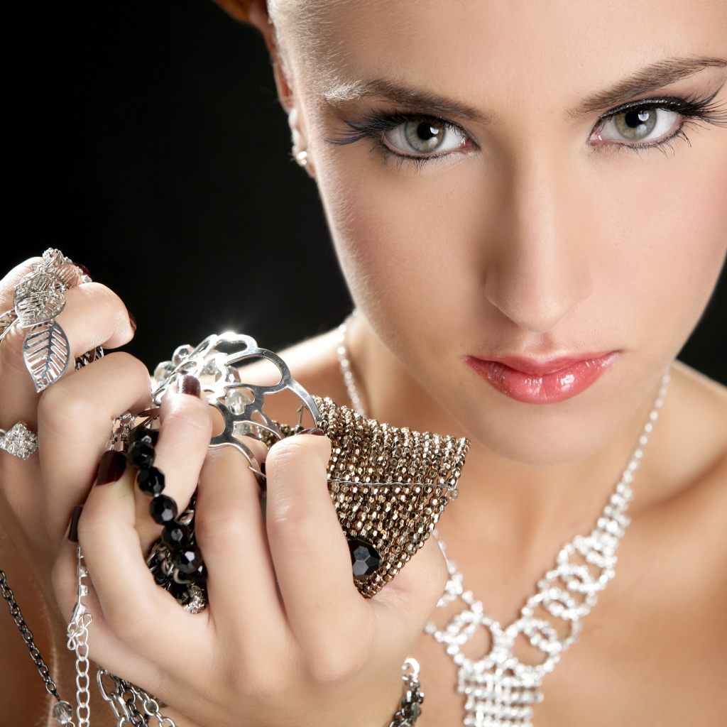 Девушка с красивыми глазами с украшениями в руках